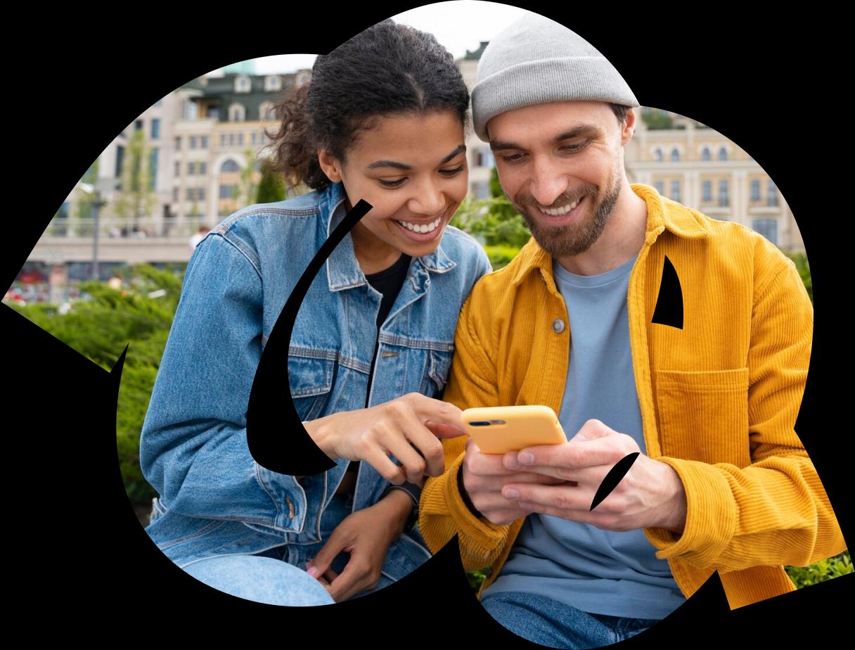 woman and man look at phone ang smile